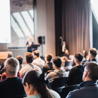 female,speaker,giving,a,talk,on,corporate,business,conference.,unrecognizable